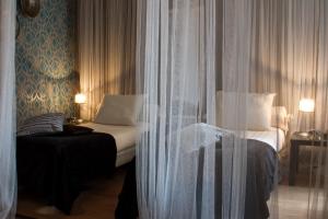 a bedroom with a bed and a window with curtains at Hotel Matuchi in Maastricht
