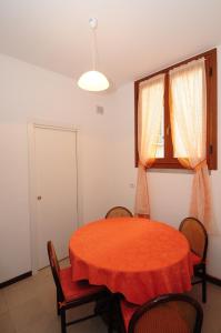 una sala da pranzo con tavolo e sedie rossi di Fiò & Giò a Varenna