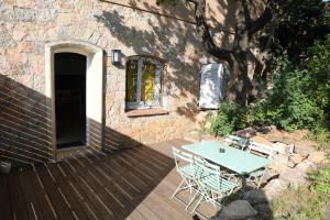 een tafel en stoelen op een houten terras bij Le Nautile in Hyères