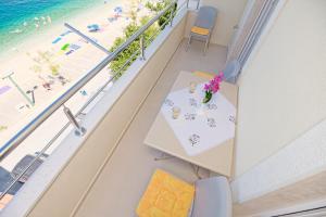 een balkon met een tafel en uitzicht op het strand bij Apartman More&Maslina in Drasnice