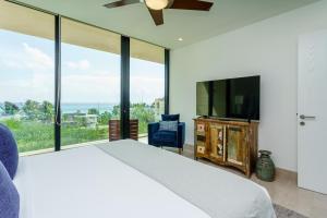 a bedroom with a bed and a flat screen tv at Oceana by ABNA in Playa del Carmen
