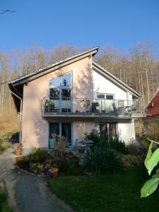 a white house with a balcony on top of it at Ferienwohnung Am Wildmeisterweg in Wernigerode