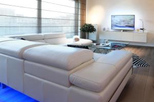 a living room with a white couch and a table at Luxury Suite Koksijde 301 Adult only in Koksijde