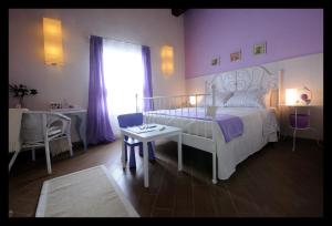 a bedroom with a bed and a table and a window at Locanda Della Fiorina in San Felice sul Panaro