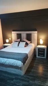 - une chambre avec un grand lit et 2 tables de chevet dans l'établissement El rincón de los Lanchares, à Sotillo de la Adrada