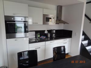 a kitchen with white cabinets and stainless steel appliances at Backbord Und Steuerbord in Stralsund