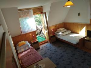 a bedroom with two beds and a window with a balcony at Pokoje u Tadeusza in Zakopane