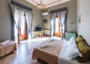 1 dormitorio con 2 camas en una habitación con ventanas en Terrazza Santa Chiara, en Catania