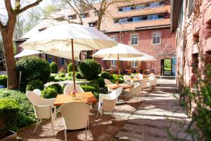 eine Terrasse mit Tischen, Stühlen und Sonnenschirmen in der Unterkunft Mühle am Schlossberg in Wartenberg-Rohrbach