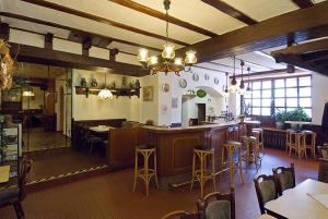 ein Restaurant mit einer Bar und einigen Tischen und Stühlen in der Unterkunft Hotel Schütz in Trier