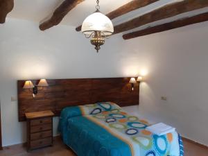 a bedroom with a bed and a chandelier at Alojamiento Rural ERMITA SAN JULIAN in Burunchel +61 photos