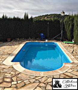 a swimming pool with blue water in a yard at Dehesa Elías in Lucena