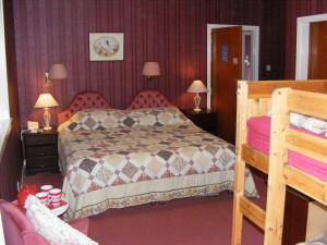 ゲイロックにあるGairloch Highland Lodgeのベッドルーム1室(ベッド1台、テーブル2台、ランプ2つ付)