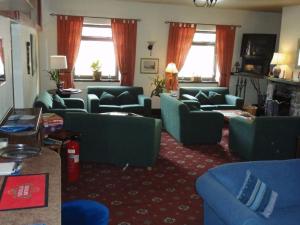 a living room with couches and chairs and windows at Gairloch Highland Lodge in Gairloch