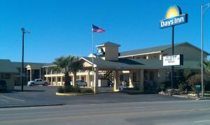 a davis inn with an american flag in a parking lot at Days Inn by Wyndham Snyder in Snyder