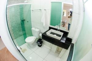a bathroom with a sink and a toilet and a mirror at Marlindo Hospedagem in Penha +49 photos