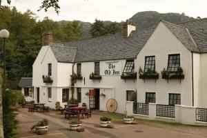 Una posada blanca con un cartel que lee la posada de las armas en The Old Inn, en Gairloch