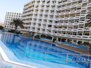 a hotel with a large swimming pool in front of a building at Apartamento Tobias Agaete Parque Playa del Ingles in San Bartolomé de Tirajana