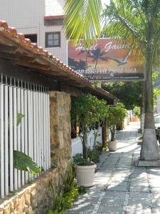 a street with a fence and trees and a building at Hotel Gaivota in Itacuruçá