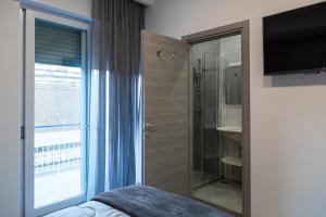 a bedroom with a shower and a bathroom with a television at Amica geniale in Naples