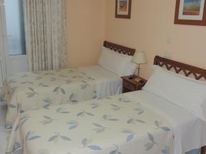 2 camas en una habitación de hotel con 2 camas sidx sidx sidx en Hostal Gonzalo, en Madrid
