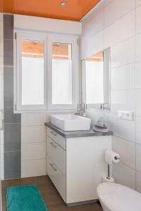 ポンタルリエにあるAppartement entier - Toile tendue - Wifiのバスルーム(洗面台、トイレ付)、窓2つが備わります。