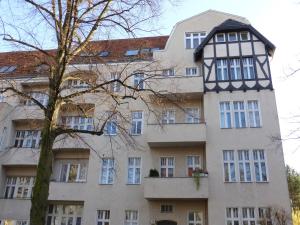 an apartment building in front of a tree at Apartments Dahlie & Nelke in Berlin