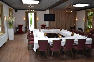 een grote vergaderzaal met een lange tafel en stoelen bij Hotel-Restaurant Het Rechthuis in Muiderberg