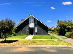 a black house with a window on the side of it at Murray's Place on Pakenham in Echuca