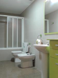 La salle de bains blanche est pourvue de toilettes et d'un lavabo. dans l'établissement Apartamento Rural Arluzepe, à Echarri-Aranaz