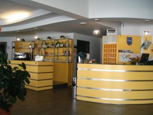 una tienda con armarios amarillos y una encimera en una habitación en Dama Hotel en Fossano