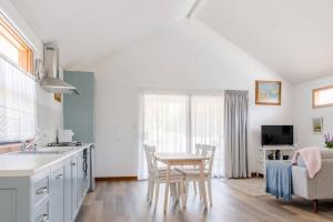 a kitchen with a table and a dining room at Bird In Hand Cottage, Port Noarlunga in Port Noarlunga