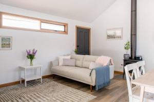 a living room with a couch and a table at Bird In Hand Cottage, Port Noarlunga in Port Noarlunga