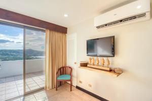 a room with a tv and a chair and a balcony at Villa Sol 66-3 in Playa Hermosa