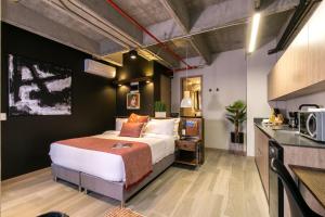 a hotel room with a bed and a kitchen at Factory Lofts Hotel in Medellín