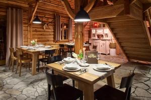 a dining room with wooden tables and chairs at Chata Walichnowska in Sokolniki