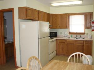 eine Küche mit einem weißen Kühlschrank und Holzschränken in der Unterkunft Cape Hatteras Motel in Buxton