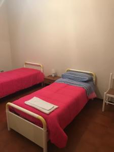 two beds in a room with red and blue sheets at Villaggio Lamezia Golfo in Lamezia Terme