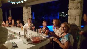 Apartments Villa Papalina 2 في راب: مجموعة من النساء يجلسن على طاولة مع كؤوس للنبيذ