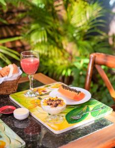 a table with a plate of food and a glass of wine at Plaza Inn Pousada do Capitão in Ilhabela