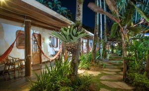 a resort with a palm tree in the yard at Plaza Inn Pousada do Capitão in Ilhabela