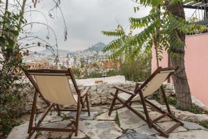 two chairs sitting on a patio with a view at Anafiotika hideaway acropolis Athens by Cycladica in Athens