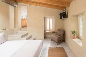 a bedroom with a bed and a chair and stairs at Anafiotika hideaway acropolis Athens by Cycladica in Athens
