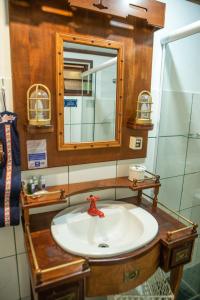 a bathroom with a sink and a mirror at Plaza Inn Pousada do Capitão in Ilhabela