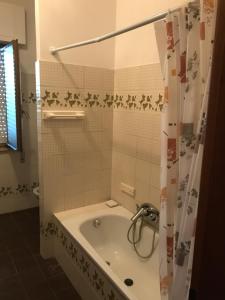 a bathroom with a tub and a shower curtain at Villaggio Lamezia Golfo in Lamezia Terme