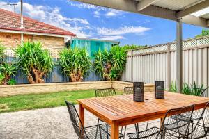 a wooden table and chairs on a patio at The Barton - Easy Tram to City in Thebarton