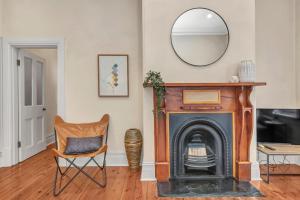 a living room with a fireplace and a mirror at The Barton - Easy Tram to City in Thebarton