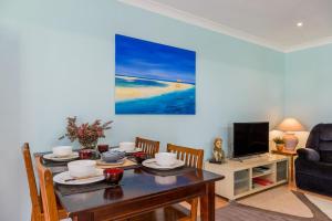 a dining room with a table and a tv at Jetz Bungalow in Berrara