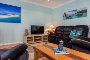 a living room with two couches and a television at Jetz Bungalow in Berrara