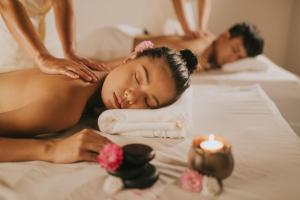 Ein Mann und eine Frau bekommen eine Massage im Bett in der Unterkunft The Royal Mandaya Hotel in Davao City